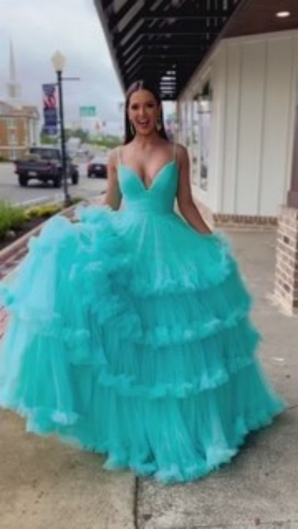 A-line V-neck tulle ball gown with double straps and multi-layered ruffles. Customizable in multiple colors.